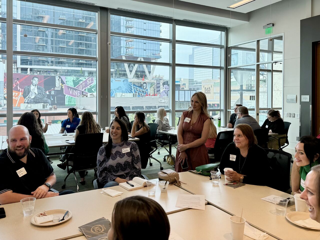 Room of talent professionals sitting around tables, talking